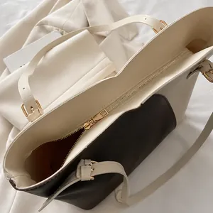 Detail view of smooth golden zipper and refined stitching on contrast tote bag