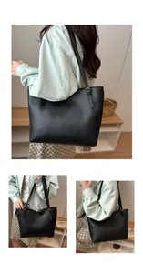 Detail of black leather tote bag featuring gold adjustable buckles and curved stitching