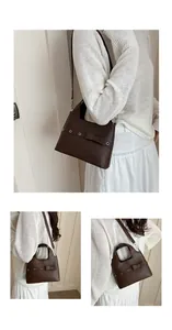 Detail view of dark brown PU leather bucket bag with bow and silver eyelets