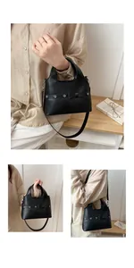 Detail of black PU leather bag showing bow decoration, metal eyelets and dual handles