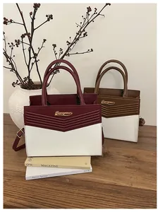 Detail of elegant two-tone handbags with V-quilted texture and gold metallic hardware