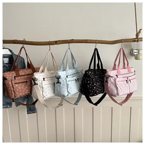 Bloemige draagtassen in diverse kleuren aan een tak met een handig multi-pocket ontwerp