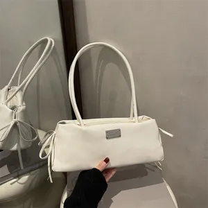 Glossy white baguette shoulder bag with side bows and silver logo plaque detail