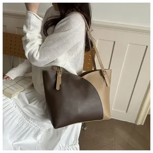 Detail of adjustable metal buckle and contrast stitching on a stylish bicolor tote bag