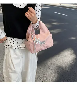 Détail du sac à main rose en nylon avec motifs étoiles, breloque et texte Good Luck