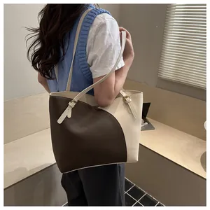 Detail of contrast color tote bag with adjustable metal buckle and smooth faux leather finish