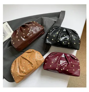 Detalle de bolsos de mano con grabado de cocodrilo y tachuelas doradas vintage