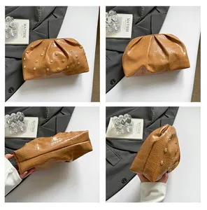 Bolso de mano marrón efecto cocodrilo con tachuelas doradas y detalles plisados