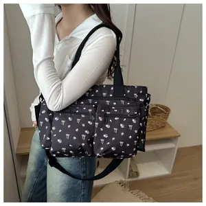 Detail van zwarte bloemen shopper met functionele zakken en handgrepen van singelband