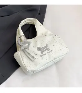 Détail du sac blanc avec imprimés étoiles, broderie chien et texte Good Luck