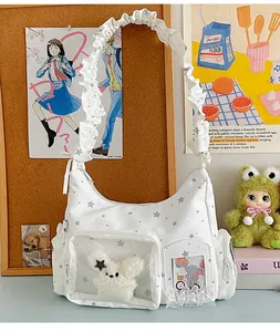 Detail der weißen Ita-Bag mit Sternmuster, Klarsichtfenster und Plüschhasen-Anhänger