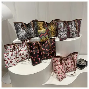 Détail de sacs cabas tendance avec imprimés serpent et cerises et leurs petites pochettes