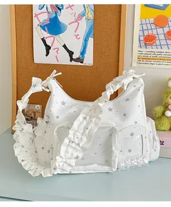 Detail der weißen Ita-Tasche mit Sternenmuster, transparentem Fenster und Rüschenriemen