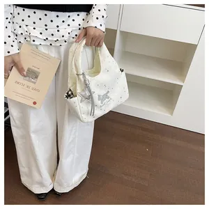 Détail du sac à main crème avec motifs étoiles, broderie et pendentif étoile chic