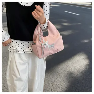 Gros plan sur un sac à main rose à motifs étoiles avec pendentif chien mignon
