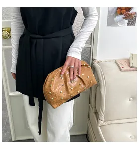 Cartera marrón con textura de cocodrilo, tachuelas doradas y diseño plisado