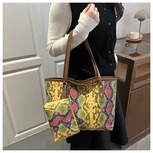 Détail d'un sac cabas à motif serpent coloré avec pochette assortie et anses brunes