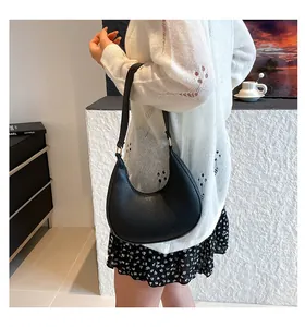Detailed close-up of a black crescent moon shoulder bag with pebbled leather texture