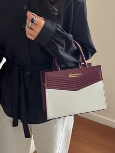 Elegant burgundy and white contrast handbag with gold logo and textured pattern detail