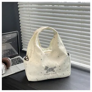 Gros plan du sac en toile beige avec motifs d'étoiles et broderie de chien terrier