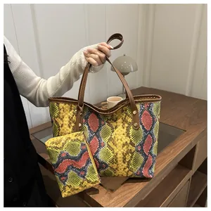 Gros plan sur le sac fourre-tout à motif serpent avec une pochette zippée assortie