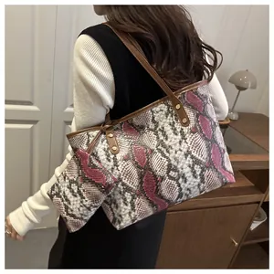 Détail du sac cabas imprimé serpent avec anses en cuir marron et mini pochette