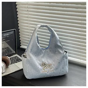 Gros plan sur le sac à main bleu clair avec étoiles argentées et broderie Good Luck
