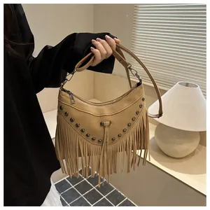 Detail of bohemian khaki suede handbag with long tassels and metallic stud accents