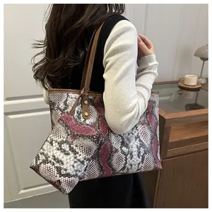 Détail du sac cabas à motif serpent rose avec pochette assortie sur un mannequin