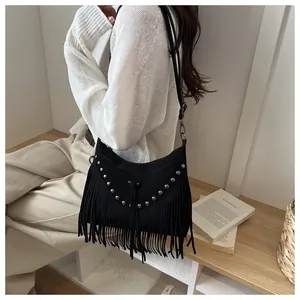 Detail of bohemian black suede bag with silver studs and long fringe tassels