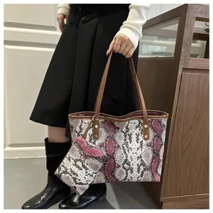 Vue détaillée de la texture serpent du cabas avec rivets renforcés et pochette assortie