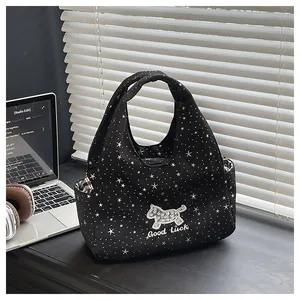 Détail du sac à main noir étoilé avec patch chiot séquin et slogan porte-bonheur