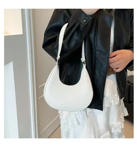 Detail of white hobo bag with pebble leather texture and gold hardware on model