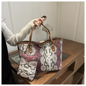 Détail du sac cabas à motif serpent avec pochette assortie et rivets dorés brillants