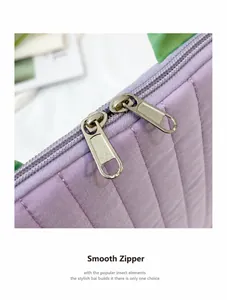 Detail of smooth metal double zippers on light purple quilted tablet sleeve storage bag