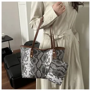 Détail du sac cabas imprimé serpent avec anses en cuir marron et pochette zippée
