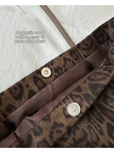 Detail view of the secure hardware magnetic buckle and leopard print fabric on a tote bag