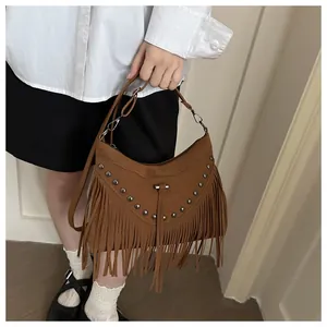 Detailed close-up of brown suede bohemian bag with metallic studs and long fringe tassels