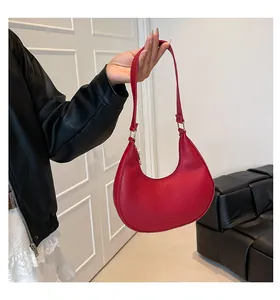 Detail shot of a red crescent moon shoulder bag featuring premium lychee texture leather