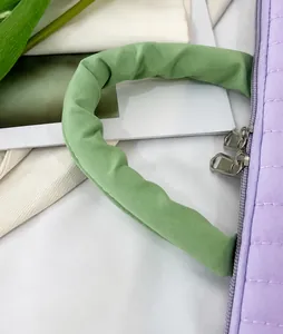 Detail of purple quilted tablet sleeve with vibrant green padded handle and double zippers
