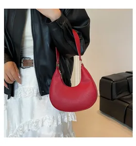 Close-up of red crescent moon bag with premium litchi grain texture and gold hardware