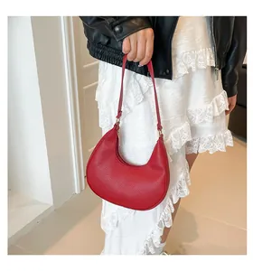 Detailed macro view of the red lychee pattern leather on a crescent underarm bag