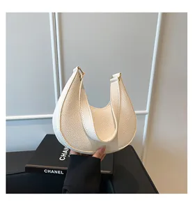 Close-up of creamy white lychee grain leather texture and gold buckle on hobo bag