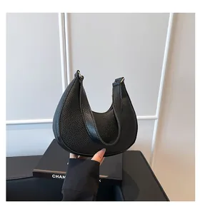 Close-up of black lychee grain leather hobo bag with sleek curves and golden hardware
