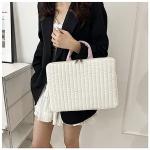Detail of quilted white laptop sleeve with pink handles and sturdy dual metal zippers