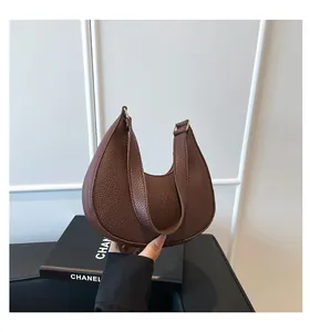 Close-up of brown crescent bag showing high-quality lychee grain leather texture