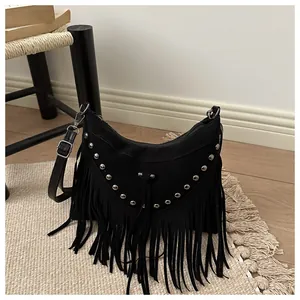 Detail of bohemian black suede crossbody bag with silver studs and long fringe tassels