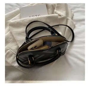 Interior view of shell-shaped crossbody bag showing phone, wallet, and cosmetics storage