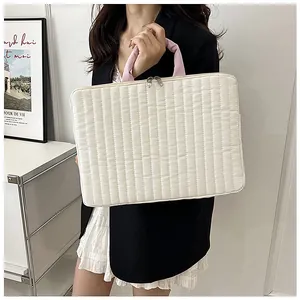 Detail of quilted laptop sleeve with pink handles and silver zippers in lifestyle setting