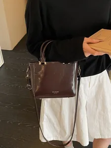 Classic dark brown glossy square handbag with top handle and adjustable shoulder strap
